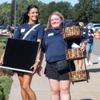 2 Alumna carrying new lakers� supplies, posing and smiling at camera